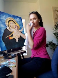 a woman is sitting in front of a painting