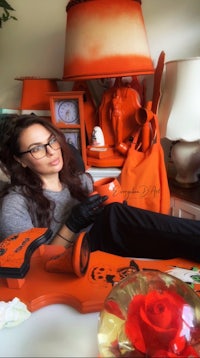 a woman sitting in front of a table with a lot of orange decorations