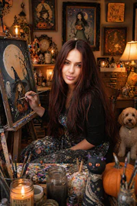 a woman sitting in front of a painting with a dog in the background